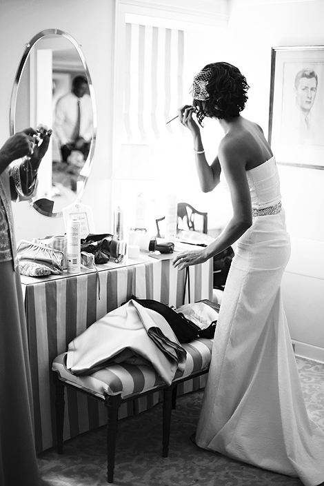 The bride applies makeup in front of an oval mirror at Appleford Estate in Villanova for final preparations before the ceremony, wedding photography by Peter Van Beever