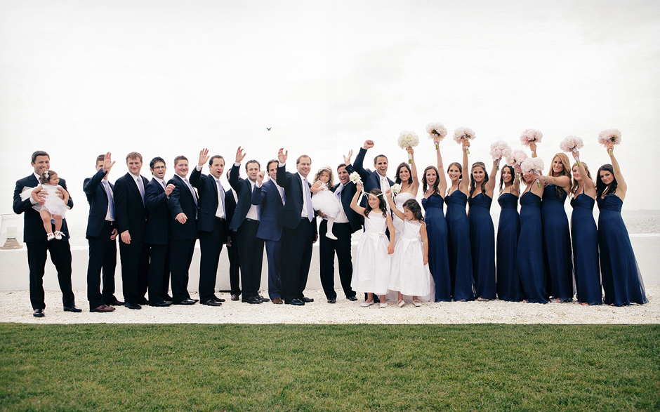Bridal party celebrates after the wedding ceremony at the Belle Mer in Newport Rhode Island, with the beach and ocean at their backs