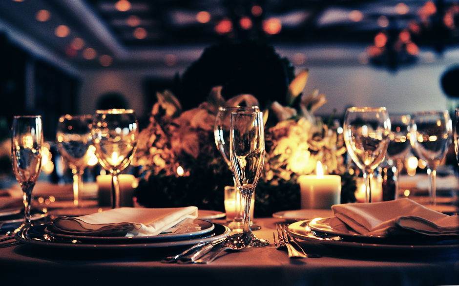 Glasses and table settings look beautiful and elegant in the candle lighting for this wedding